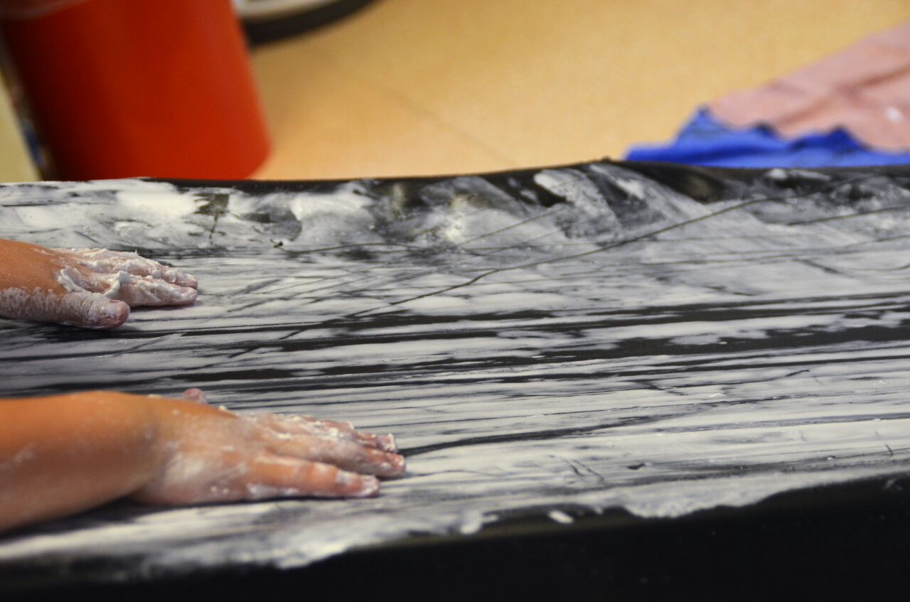 Kinderhände schmieren Creme auf Rutsche